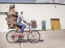 Verzerrtes Foto Mann auf Fahrrad mit vielen Paketen
